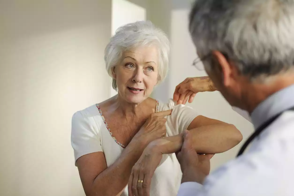 Patient showing doctor her frozen shoulder pain