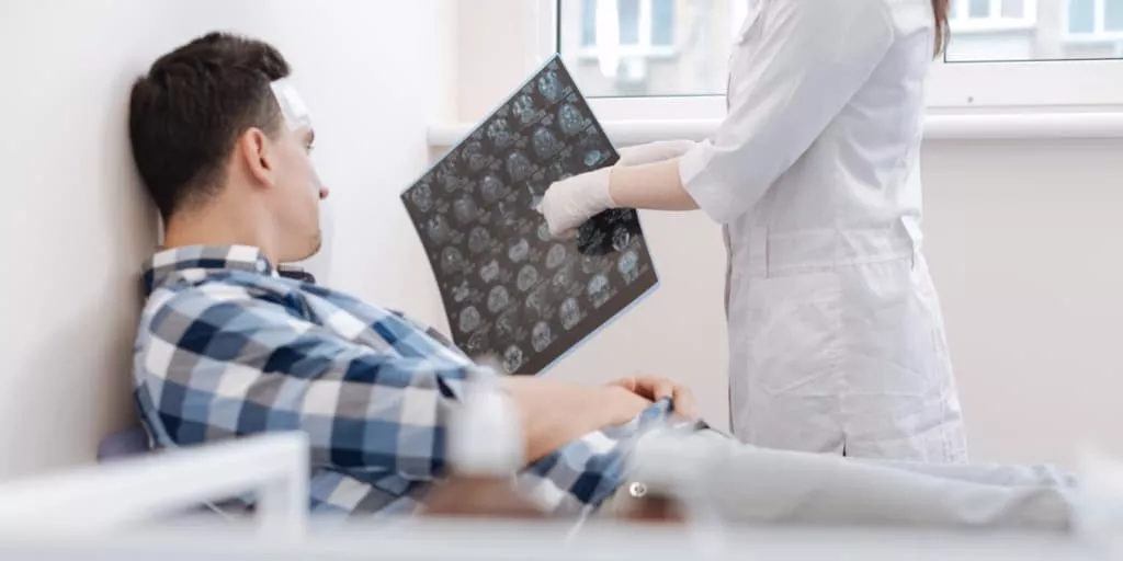 Doctor looking at an xray of the head with patient with a possible concussion