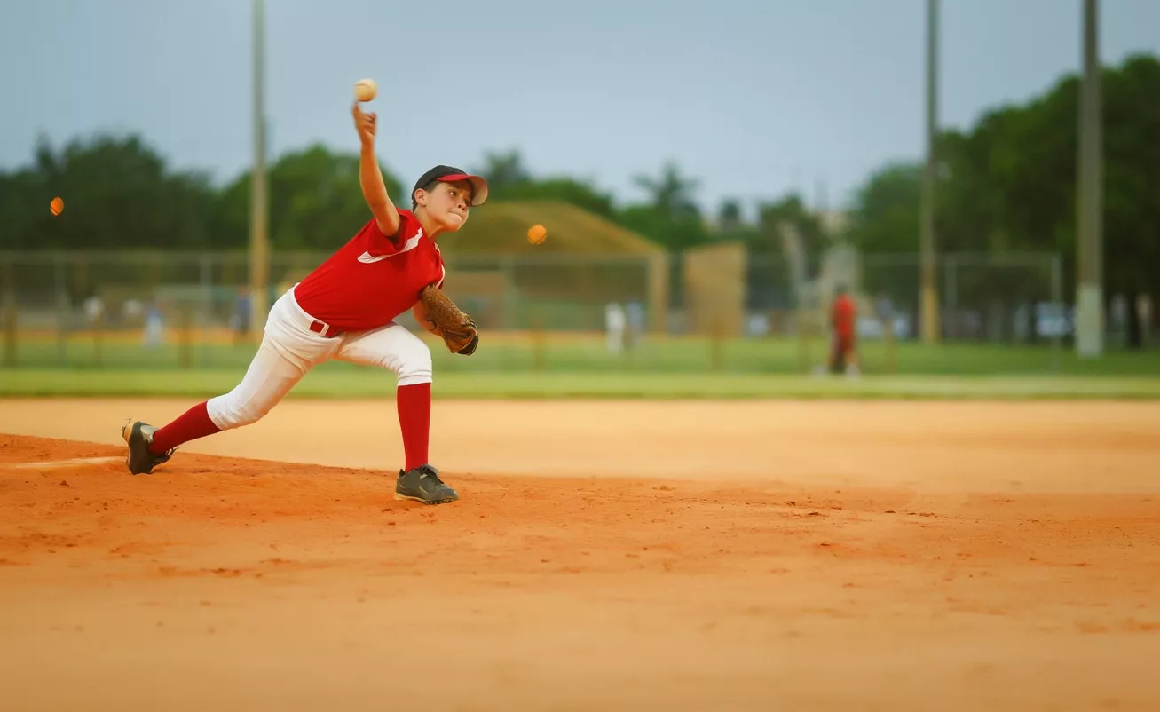 young pitcher throwing a fast ball / 11-12 years old league. Throwing injuries concept