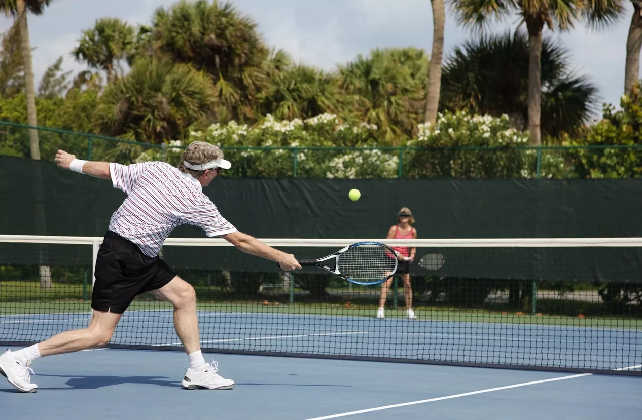 retired senior couple playing tennis at the club