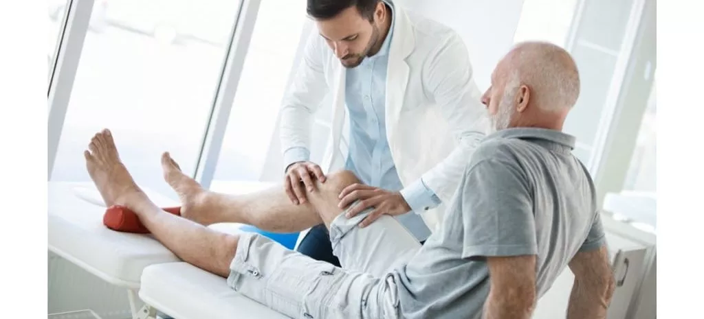 Senior man with a physical therapist. He is looking for a Baker’s Cyst due to knee pain