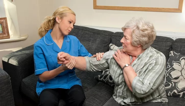 Young physical therapist checks senior with neck pain and arm tingling for cervical fusion