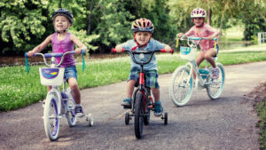 Three children riding bikes together