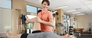 Woman assisting a patient with physical therapy