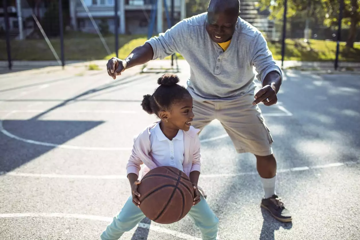 grandfather playing basketball with granddaughter