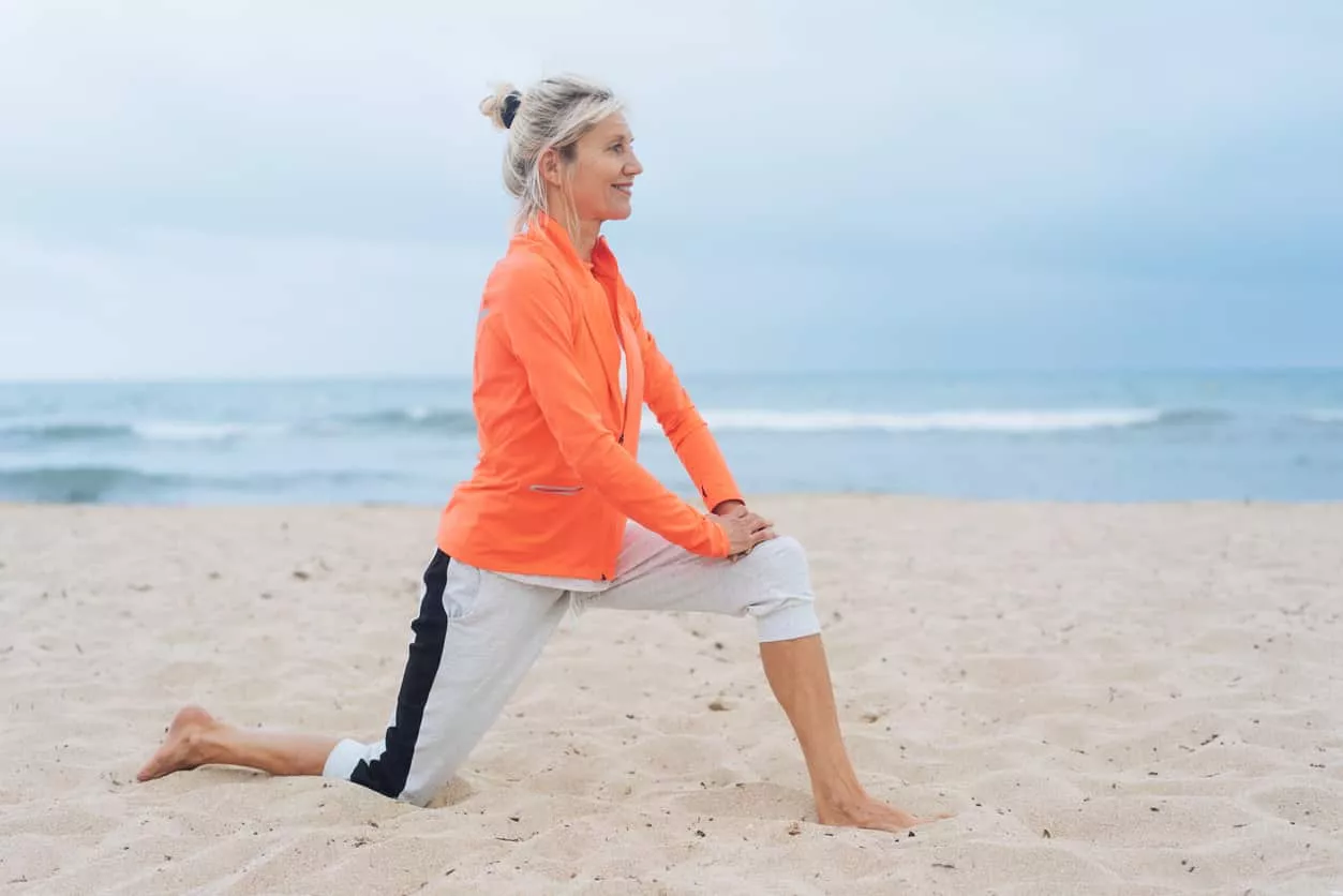 stretching knee on beach