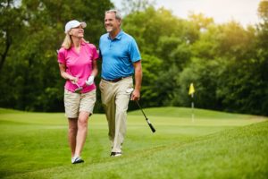 Golfer husband and wife walking on a golf course