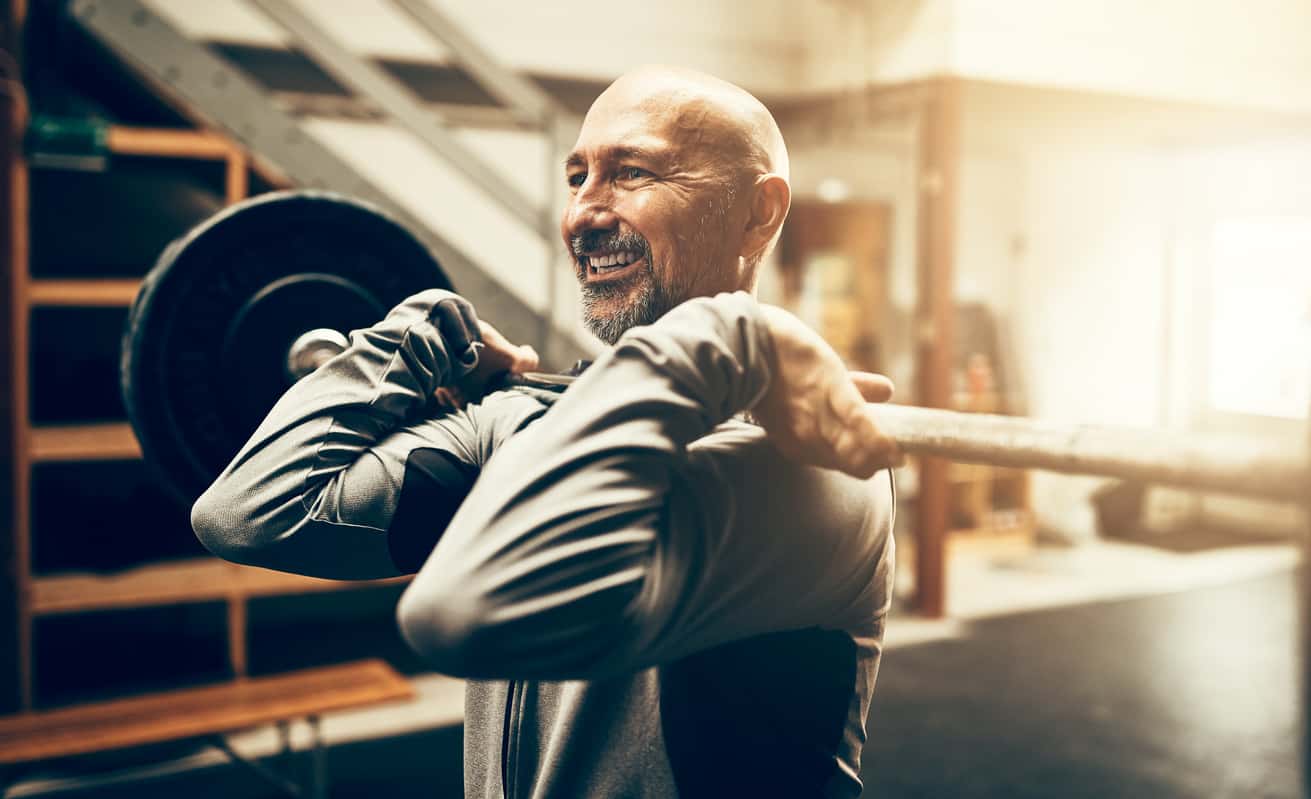 A middle-aged man performing a barbell lift