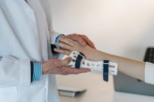 A doctor putting a brace on a patient’s wrist to treat tendonitis