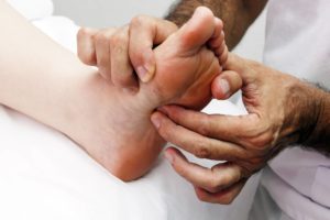 Close-up of a physical therapist assessing a patient’s peripheral neuropathic foot pain