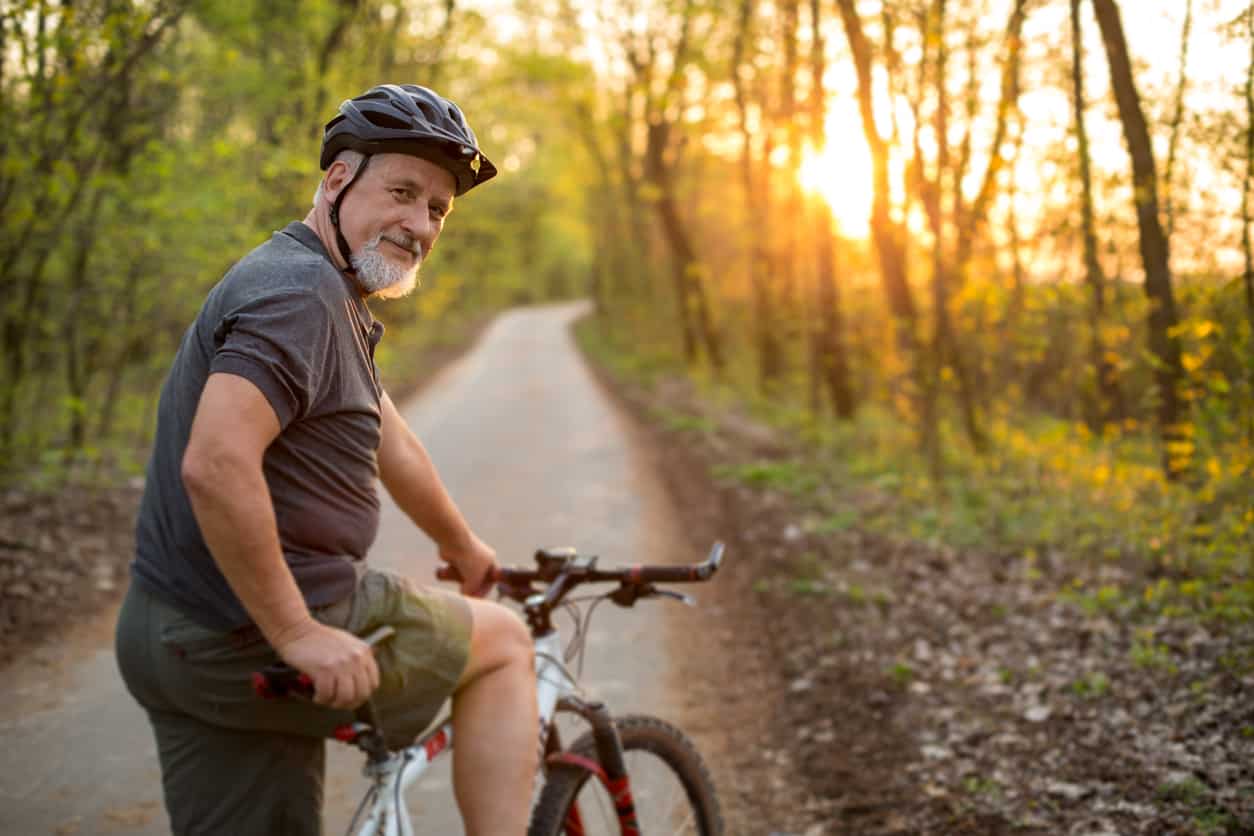Senior man biking on a trail