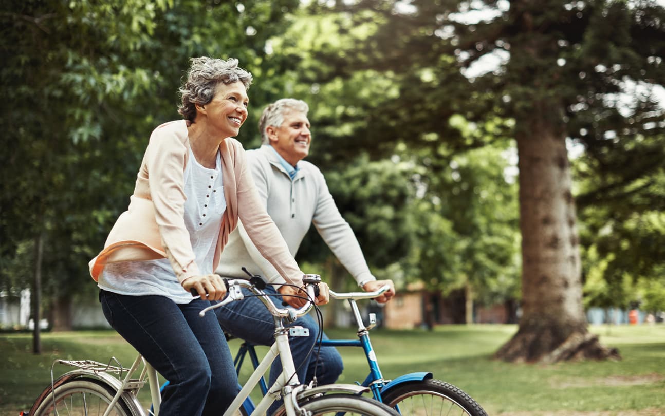 Two senior couples enjoying a bike ride outside to help relieve lower back pain.